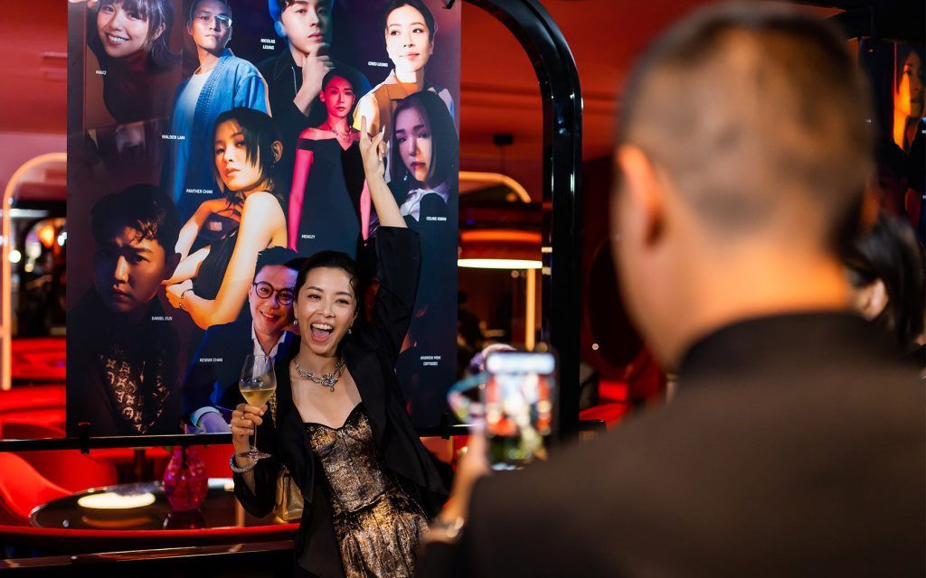 Guest poses with 40 Under 40 2022 backdrop