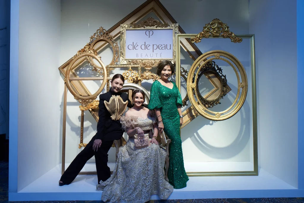 Guests pose with Cle de peau backdrop